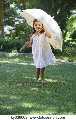 Cute little girl holding an umbrella View Large Photo Image Stock Photo - Cute little girl holding an umbrella. Fotosearch