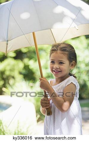Cute little girl holding an umbrella View Large Photo Image Stock Photograph - Cute little girl holding an umbrella. Fotosearch