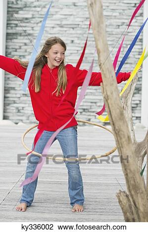 Girl playing with a plastic hoop View Large Photo Image Stock Image - Girl playing with a plastic hoop. Fotosearch