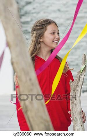Girl standing near a decorated tree and smiling View Large Photo Image Stock Image - Girl standing near a decorated tree and smiling. Fotosearch
