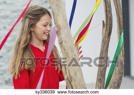 Girl standing near a decorated tree and smiling View Large Photo Image Stock Photo - Girl standing near a decorated tree and smiling. Fotosearch