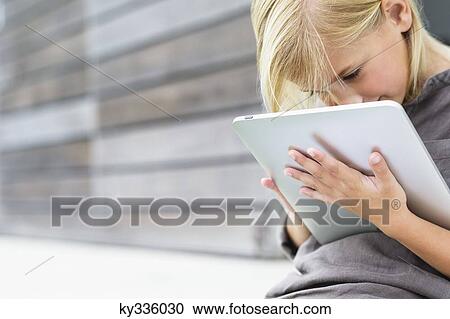 Stock Image - Girl using a digital tablet. Fotosearch