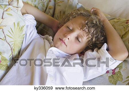 Stock Photo - Little boy sleeping on couch. Fotosearch