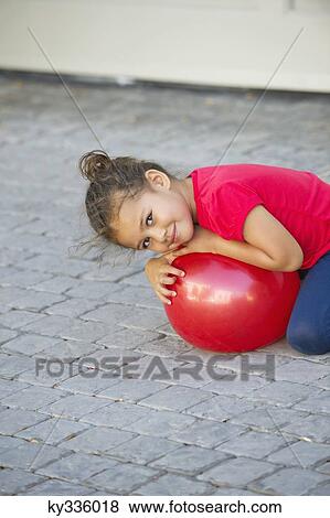 Portrait of a cute little girl playing with ball View Large Photo Image Stock Photo - Portrait of a cute little girl playing with ball. Fotosearch