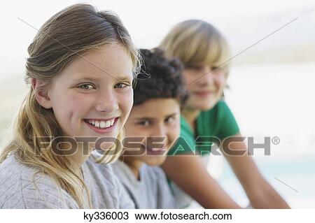 Portrait of a girl smiling with her two brothers View Large Photo Image Stock Image - Portrait of a girl smiling with her two brothers. Fotosearch
