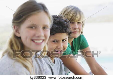 Portrait of a girl smiling with her two brothers View Large Photo Image Stock Image - Portrait of a girl smiling with her two brothers. Fotosearch