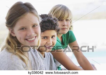 Portrait of a girl smiling with her two brothers View Large Photo Image Stock Image - Portrait of a girl smiling with her two brothers. Fotosearch