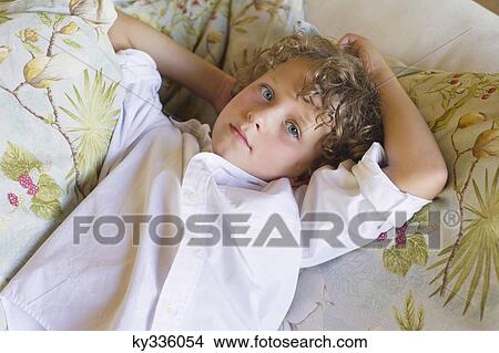 Portrait of a little boy lying on couch View Large Photo Image Picture - Portrait of a little boy lying on couch. Fotosearch