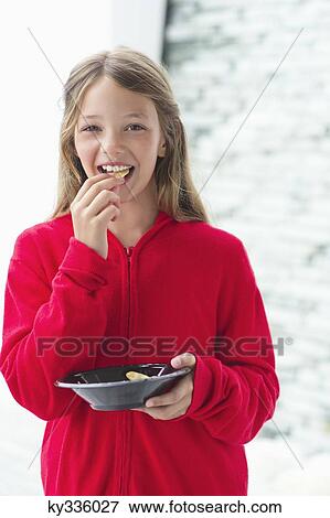 Stock Photo - Portrait of a smiling girl eating food. Fotosearch