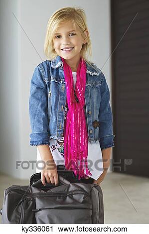 Portrait of a smiling girl standing near her luggage View Large Photo Image Stock Image - Portrait of a smiling girl standing near her luggage. Fotosearch