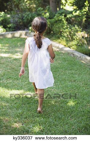 Rear view of a little girl walking in the garden View Large Photo Image Stock Photo - Rear view of a little girl walking in the garden. Fotosearch