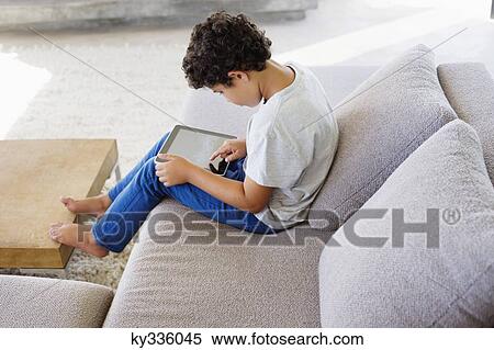Side profile of a boy using a digital tablet View Large Photo Image Stock Photography - Side profile of a boy using a digital tablet. Fotosearch