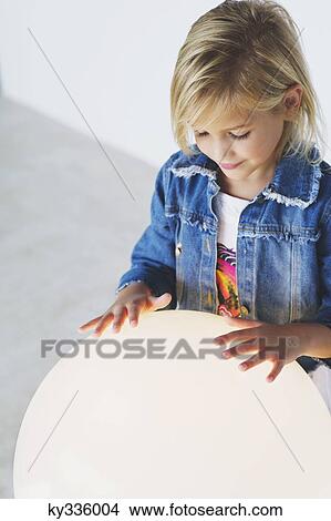Smiling girl touching an illuminated sphere View Large Photo Image Picture - Smiling girl touching an illuminated sphere. Fotosearch