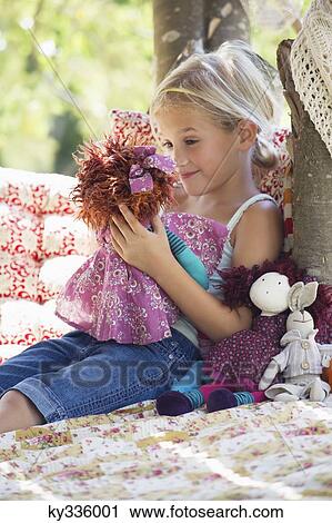 Smiling little girl holding toys in tree house View Large Photo Image Stock Image - Smiling little girl holding toys in tree house. Fotosearch