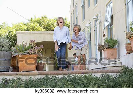 Two little children laughing outside house View Large Photo Image Stock Image - Two little children laughing outside house. Fotosearch