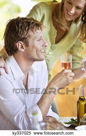 Stock Photography - Couple having drinks and smiling. Fotosearch