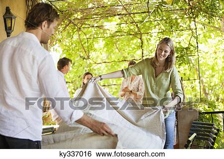 Couple preparing dining table for meal time View Large Photo Image Stock Photograph - Couple preparing dining table for meal time. Fotosearch