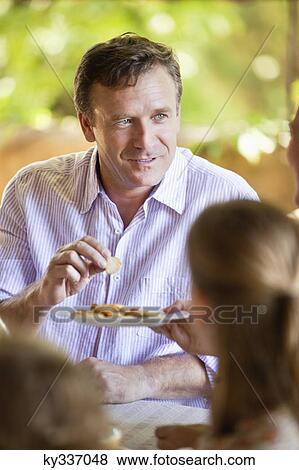 Family having meal and discussing at dining table View Large Photo Image Stock Photo - Family having meal and discussing at dining table. Fotosearch
