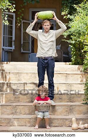 Father and son carrying fruits View Large Photo Image Stock Image - Father and son carrying fruits. Fotosearch
