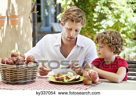 Father peeling apple with son View Large Photo Image Picture - Father peeling apple with son . Fotosearch