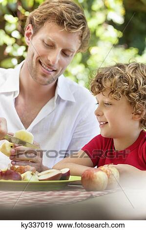 Father peeling apple with son View Large Photo Image Stock Photo - Father peeling apple with son . Fotosearch