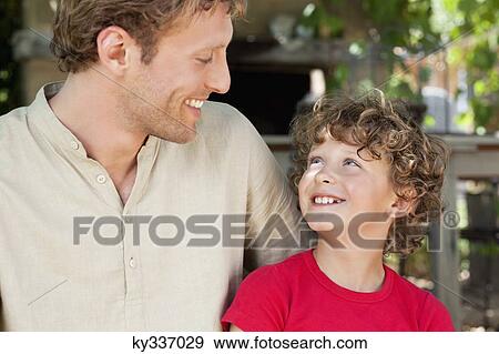 Happy father and son looking at each other View Large Photo Image Stock Photo - Happy father and son looking at each other. Fotosearch