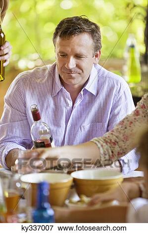 Mature man looking at a wine bottle View Large Photo Image Stock Photo - Mature man looking at a wine bottle. Fotosearch