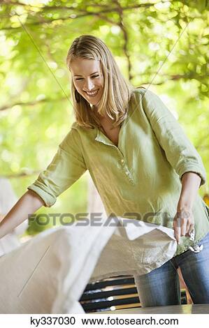 Smiling woman holding a tablecloth View Large Photo Image Stock Image - Smiling woman holding a tablecloth. Fotosearch