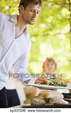 Young man serving salad View Large Photo Image Stock Photograph - Young man serving salad. Fotosearch