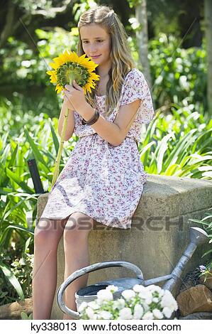 Cute little girl holding sunflower outdoors View Large Photo Image Stock Image - Cute little girl holding sunflower outdoors. Fotosearch