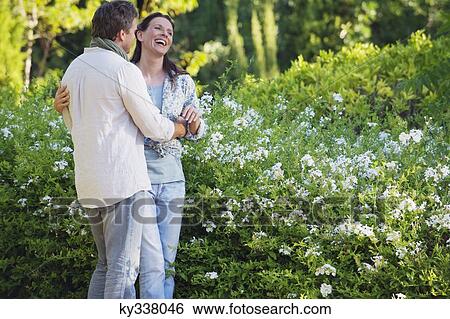 Happy mature couple romancing in a garden View Large Photo Image Stock Photograph - Happy mature couple romancing in a garden. Fotosearch