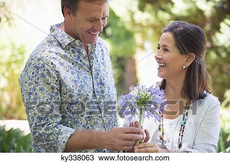 Man giving flower to his mother and smiling View Large Photo Image Stock Image - Man giving flower to his mother and smiling. Fotosearch