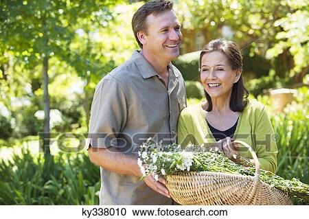 Man with his mother holding basket of flowers outdoors View Large Photo Image Stock Image - Man with his mother holding basket of flowers outdoors. Fotosearch