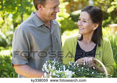 Man with his mother holding basket of flowers outdoors View Large Photo Image Stock Photo - Man with his mother holding basket of flowers outdoors. Fotosearch