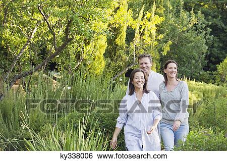 Mature couple walking with their mother in a garden View Large Photo Image Stock Photograph - Mature couple walking with their mother in a garden. Fotosearch