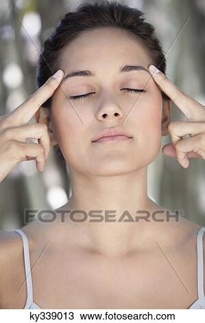 Beautiful young woman with her eyes closed and fingers on temples View Large Photo Image Stock Image - Beautiful young woman with her eyes closed and fingers on temples. Fotosearch