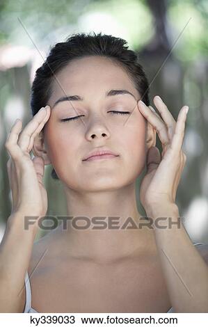 Beautiful young woman with her eyes closed and fingers on temples View Large Photo Image Stock Image - Beautiful young woman with her eyes closed and fingers on temples. Fotosearch