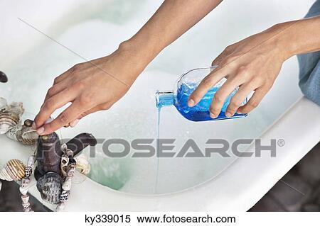 Close-up of a woman's hand pouring aromatherapy oil in a bathtub View Large Photo Image Stock Photography - Close-up of a woman's hand pouring aromatherapy oil in a bathtub. Fotosearch