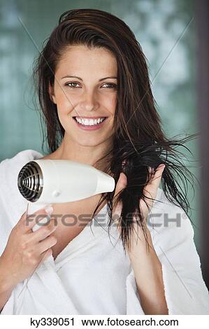 Portrait of a woman drying her hair with a hair dryer View Large Photo Image Stock Image - Portrait of a woman drying her hair with a hair dryer. Fotosearch