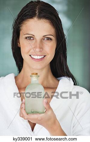 Portrait of a woman holding a bottle of aromatherapy oil and smiling View Large Photo Image Stock Image - Portrait of a woman holding a bottle of aromatherapy oil and smiling. Fotosearch