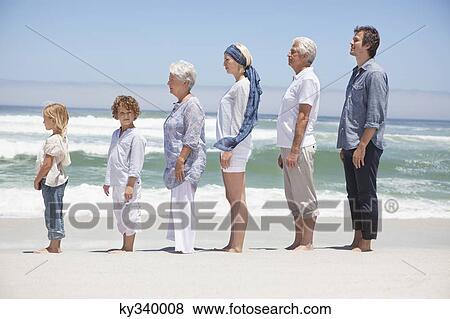 Family standing in row along the beach with kids View Large Photo Image Stock Photo - Family standing in row along the beach with kids . Fotosearch