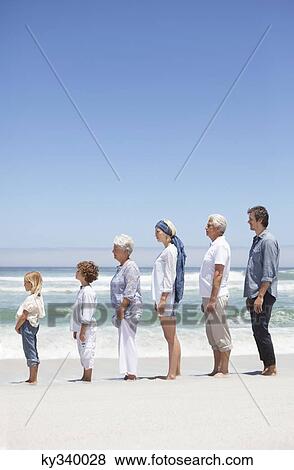 Family standing in row along the beach with kids View Large Photo Image Stock Photo - Family standing in row along the beach with kids . Fotosearch