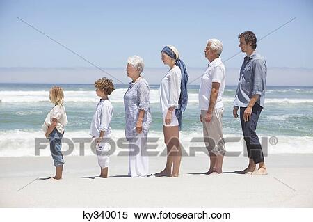 Family standing in row along the beach with kids View Large Photo Image Stock Photography - Family standing in row along the beach with kids . Fotosearch