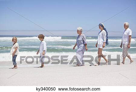 Family walking in a row along the beach with kids View Large Photo Image Stock Image - Family walking in a row along the beach with kids . Fotosearch