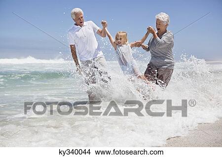 Girl enjoying on the beach with her grandparents View Large Photo Image Picture - Girl enjoying on the beach with her grandparents. Fotosearch