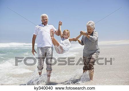 Girl enjoying on the beach with her grandparents View Large Photo Image Stock Image - Girl enjoying on the beach with her grandparents. Fotosearch