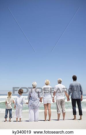 Rear view of a family looking at sea view from beach View Large Photo Image Stock Photo - Rear view of a family looking at sea view from beach. Fotosearch