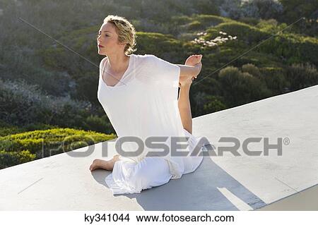 Mid adult woman practicing yoga View Large Photo Image Picture - Mid adult woman practicing yoga. Fotosearch