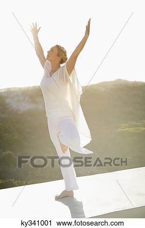 Mid adult woman practicing yoga View Large Photo Image Stock Image - Mid adult woman practicing yoga. Fotosearch