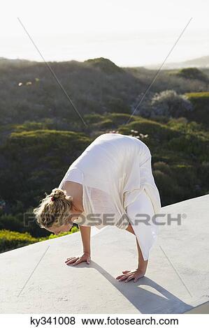Mid adult woman practicing yoga View Large Photo Image Stock Photo - Mid adult woman practicing yoga. Fotosearch